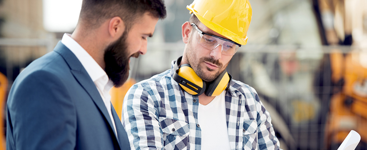 Business man and builder looking at plans on site