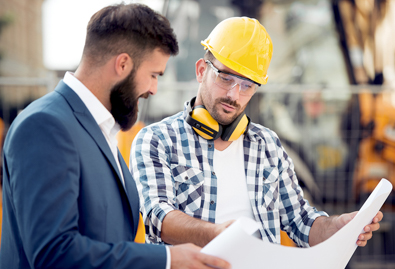 Business man and builder looking at plans on site