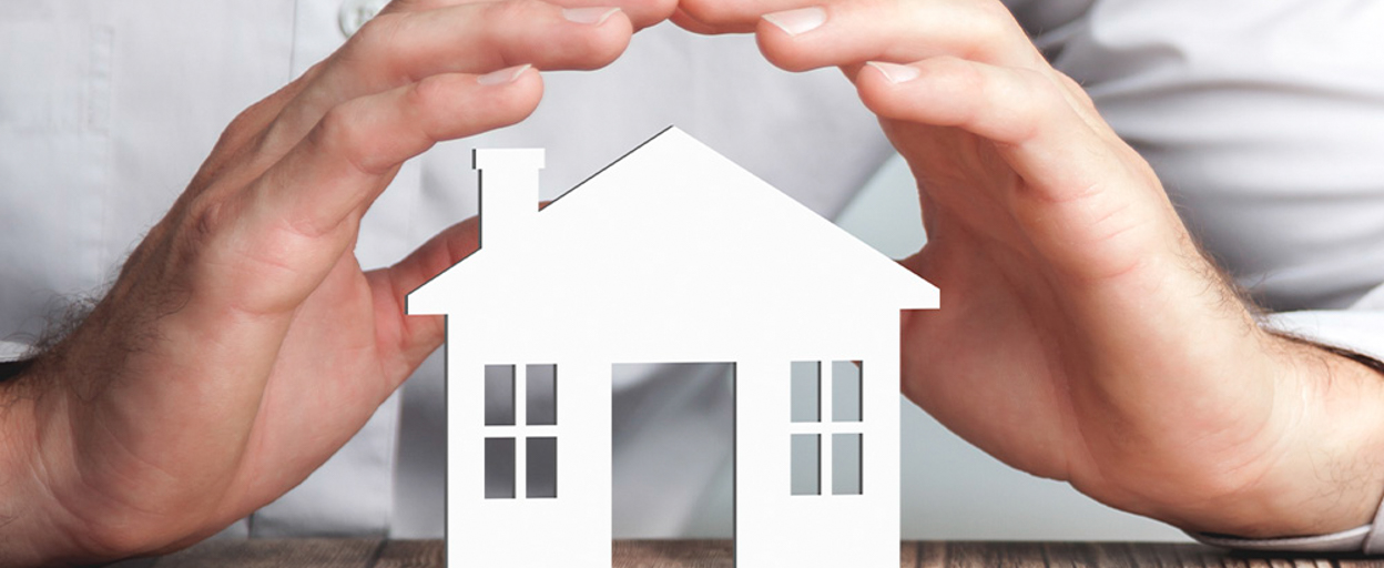 A stock image of a person holding a toy house